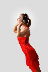 Obraz premium Young woman in evening dress with headphones