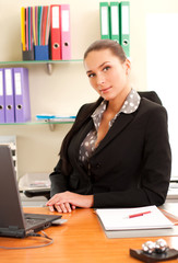 Business woman sitting in the office in front of the laptop