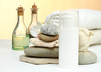 A bootle of cream in front of SPA objects on white background