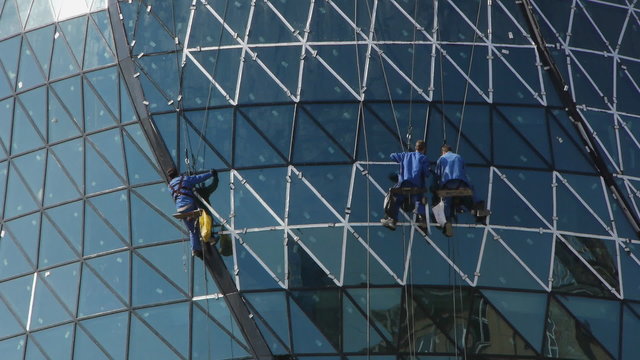 Finishing the modern building. Builders on the scaffoldings.