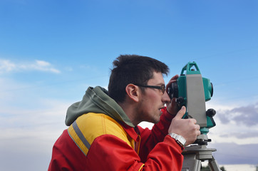 One surveyor worker working with theodolite transit equipment at