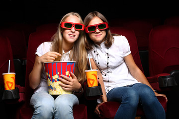 Fototapeta premium Two young girls watching in cinema