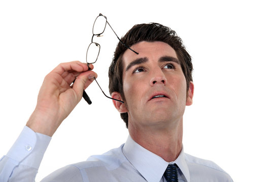 Man Taking His Glasses Off And Looking Upwards