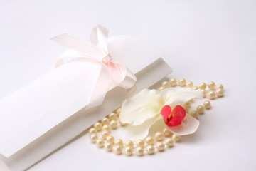 Fototapeta na wymiar Pearls with empty gift card on a white background