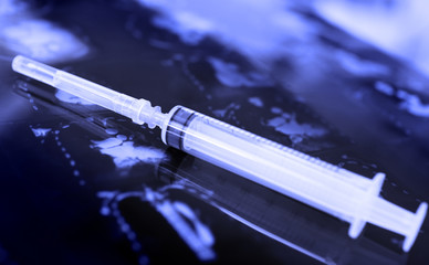 Disposable plastic syringe on the surface of the tomogram.