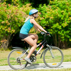 Obraz premium Young smiling woman on bike