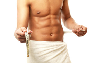 A nude young man covering himself with a towel