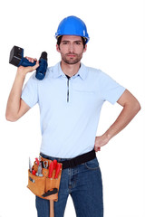 Irritated tradesman holding a battery-powered screwdriver