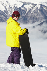 Fototapeta na wymiar Teenage Snowboarder Podziwiając jednoczesnym Mountain View On Holiday Ski