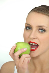 Woman biting into green apple