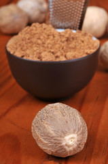 Noix de muscade et bol de muscade en poudre