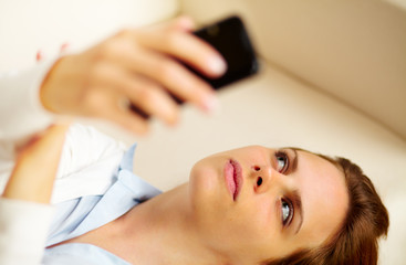Obraz na płótnie Canvas Young woman using a cellphone at home