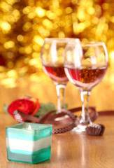 christmass dinner with rose candies and two glasses of red wine