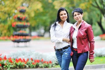 Mother with daughter walking in autumn park