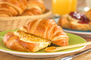 Croissant mit Butter und Orangenmarmelade
