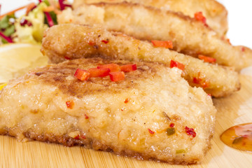 Fried fish fillets with  salad.