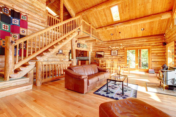 Luxury log cabin living room with leather sofa. - obrazy, fototapety, plakaty