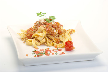 maltagliati al ragù su piatto bianco
