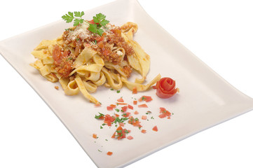 maltagliati al ragù su piatto bianco