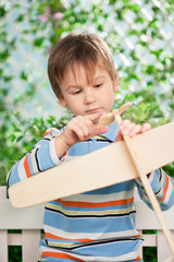 Portrait of boy with plane in a garden