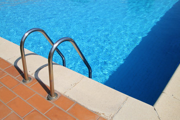 border of pool and stair, with blue calm water
