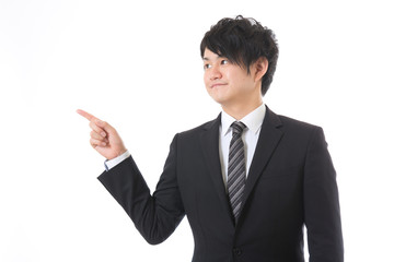 左を指差すビジネスマン