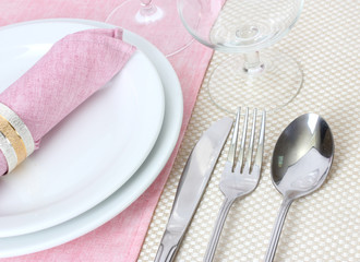 Table setting with fork, spoon, knife, plates, and napkin