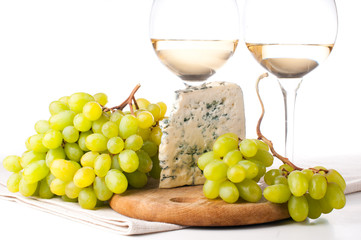Two glasses of white wine, blue cheese and a grapes