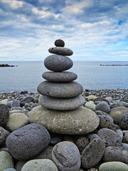Fototapeta na wymiar stack of stones on the beach and sea background