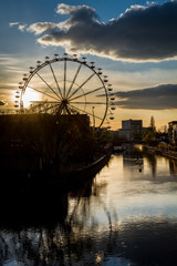 Funfair reflection in river at sunset