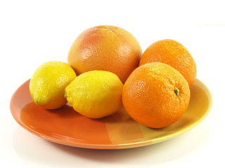 Tropical fruits on orange plate, studio isolated.
