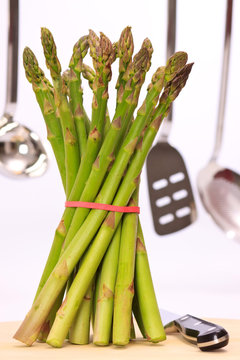 Gr&uuml;ner Spargel stehend, in der K&uuml;che auf dem Schneidebrett