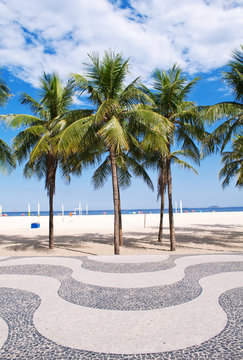View of Copacabana beach with palms and mosaic of sidewalk