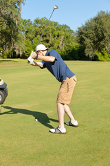 Obraz premium Young Male Golfer Preparing to Hit the Golf Ball