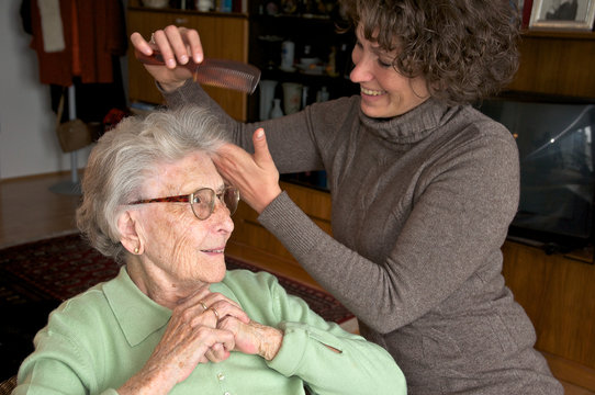 &Auml;ltere Dame mit Betreuerin beim Frisieren