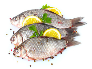 Fresh fishes with lemon, parsley and spice isolated on white