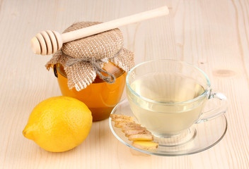 Healthy ginger tea with lemon and honey on wooden background