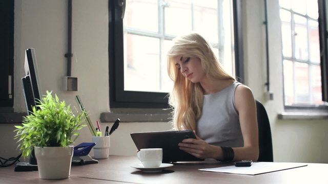 Young businesswoman working on tablet computer in office
