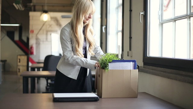 businesswoman unpacking her belongings from box in the office