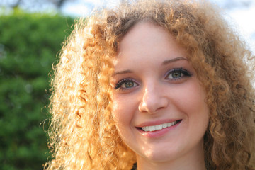 curly-haired girl smiling in the spring