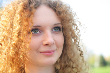 curly-haired girl in the park in spring