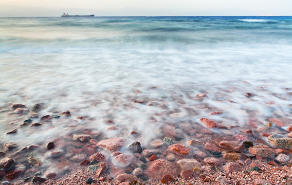 cobble stone beach of Read Sea on sunset
