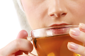 Closeup of a beautiful young woman enjoying tea