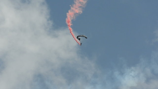 Skydivers with a trail of smoke behind