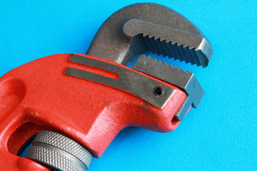 Closeup of adjustable wrench over blue