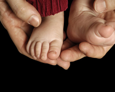 Baby feet isolated on black background