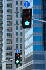 Two traffic lights against background of modern buildings.