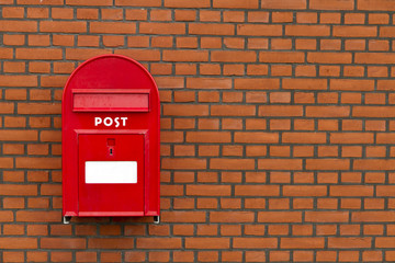 red mailbox on stone wall