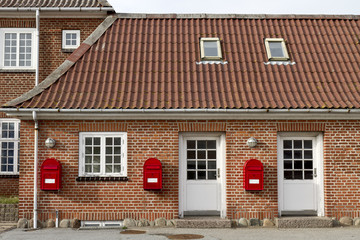 red mailboxes on stone walled house