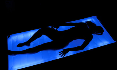 Silueta de una mujer en una cama de agua en un spa